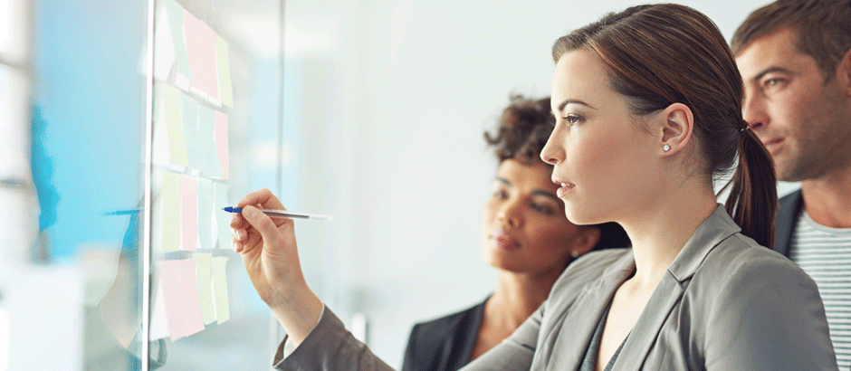 Beraterin zeigt auf Prozessdiagramm – Prozessmanagementberatung