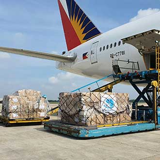 Flugzeug mit beladener Frachtpalette auf dem Rollfeld – Symbol für internationale Luftfracht und Logistik.