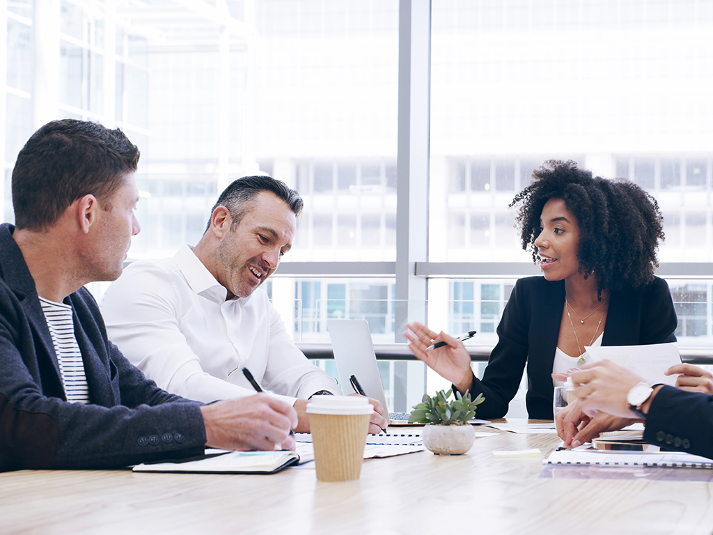 Fünf Personen im Gespräch während eines Audits