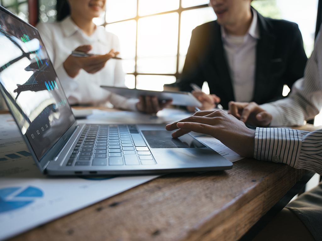 Business-Team arbeitet mit digitalen Charts und Berichten zur Vorbereitung eines Audits